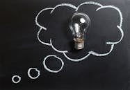 pexels-photo-355952-355952 Light bulb laying on chalkboard with drawn thought bubble, symbolizing creative ideas.