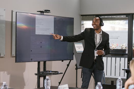 pexels-photo-7648221-7648221 Business professional presenting with a digital screen, engaging an audience at a corporate event.