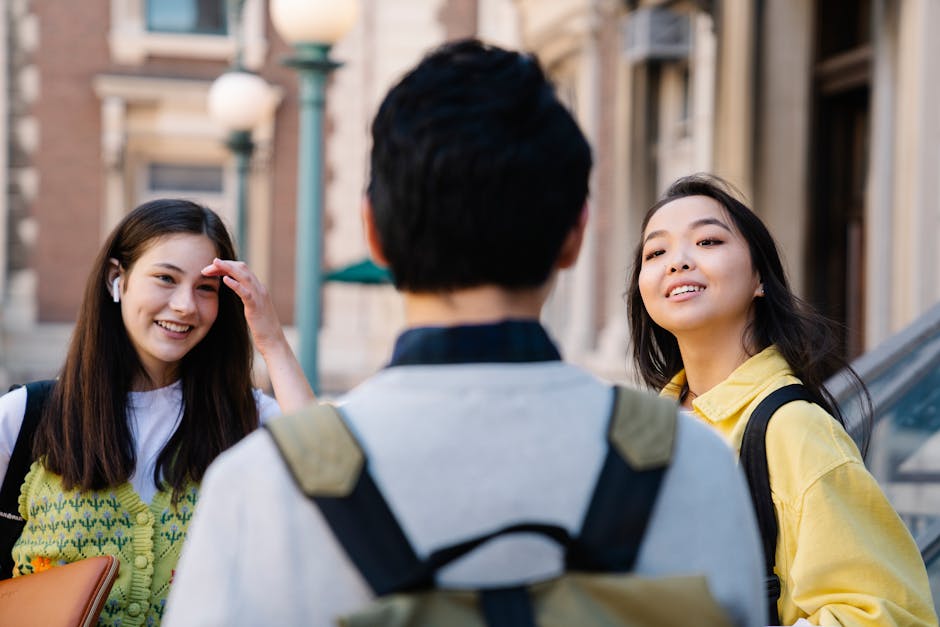 A group of diverse students enjoying a conversation outdoors on a college campus.